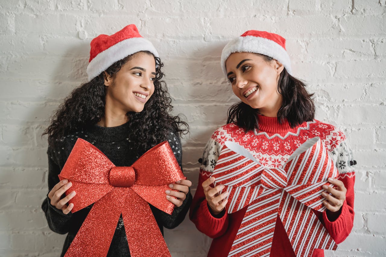 Deux femmes sourient et tiennent chacun un ruban de cadeau